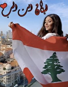 a woman holding a flag in front of a cityscape