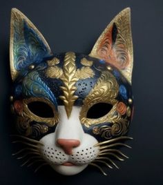 a close up of a cat mask on a black background with gold and blue details