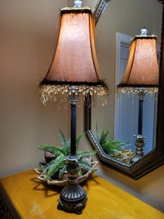 two lamps sitting on top of a table next to a mirror