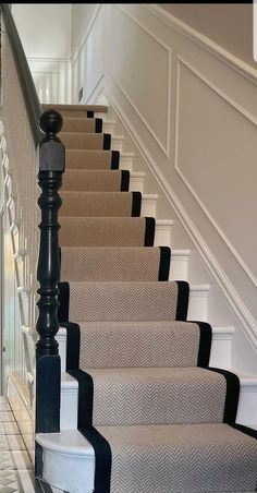 the stairs are lined with black and white carpet