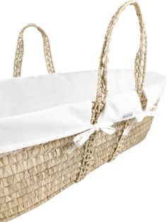 an empty wicker basket with white fabric on the handles and bottom, isolated against a white background