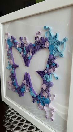 a white frame with purple and blue butterflies in the shape of a butterfly on it