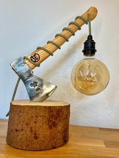 a light bulb sitting on top of a wooden table next to a hammer and shoe