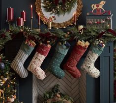 christmas stockings hanging from a mantel in front of a fireplace