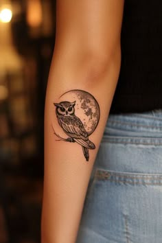 a small owl tattoo on the right arm and shoulder, with a full moon in the background