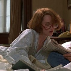 a woman laying in bed reading a book