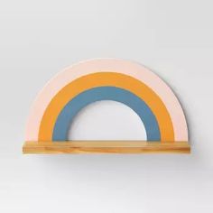 a wall mounted shelf with a rainbow painted on it's front and back sides