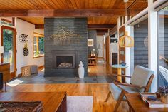 a living room with wood floors and a stone fireplace