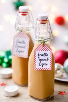 two bottles of homemade caramel liquer on a table with christmas decorations in the background