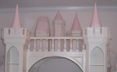 there is a white castle with pink turrets on the top and bottom floor, in front of a staircase