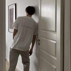 a man standing in front of a door with his hand on the side of the door