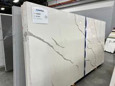 some white marbles are stacked on pallets in a room with gray walls and flooring