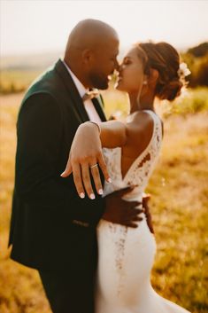 a bride and groom kissing in an open field