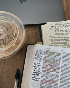 an open bible next to a laptop computer