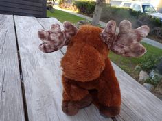 a stuffed moose sitting on top of a wooden table