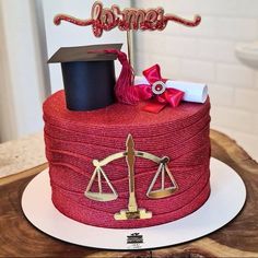 a graduation cake that is on top of a wooden table with a hat and scale