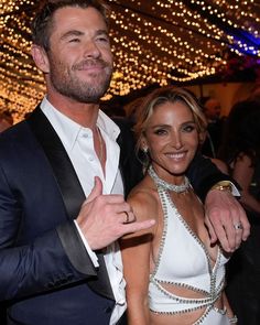 a man and woman standing next to each other in front of a ceiling full of lights