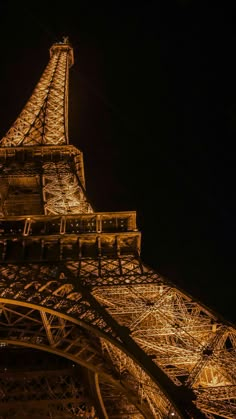 the eiffel tower lit up at night with lights on it's sides