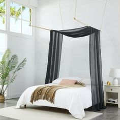 a bedroom with a canopy bed and rugs on the floor in front of it