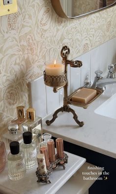 a bath room with a sink and a candle on a stand in front of a mirror