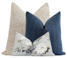 two blue and white pillows on top of each other, one with a bird in the middle