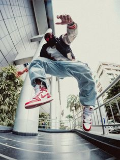 a person jumping in the air with a skateboard near a building and palm trees