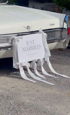 a white wedding car with ribbons tied around it