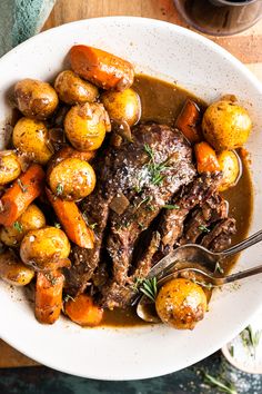 a white bowl filled with meat and potatoes