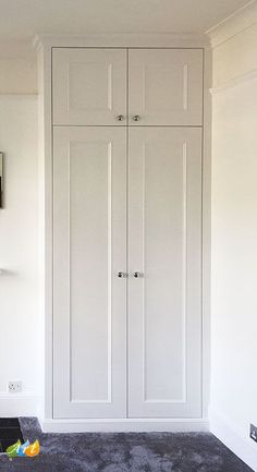 an empty room with white cupboards and carpet