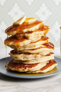 a stack of pancakes with syrup being poured on top