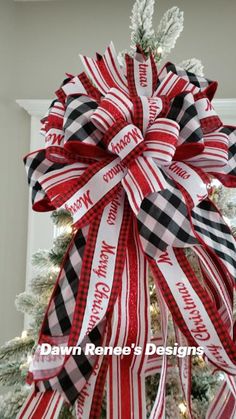 a christmas tree decorated with red, white and black ribbon