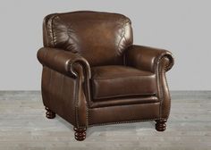 a brown leather chair with nail polishing on the armrests and foot rest