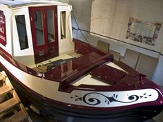 a red and white boat sitting in a room