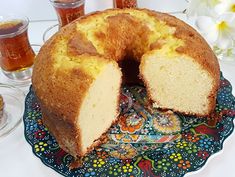 a bundt cake with one slice cut out on a plate next to two glasses