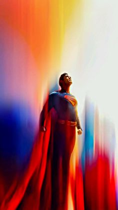 a man dressed as superman standing in front of an abstract background