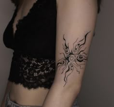 a woman's arm with a sun tattoo on the left side of her arm