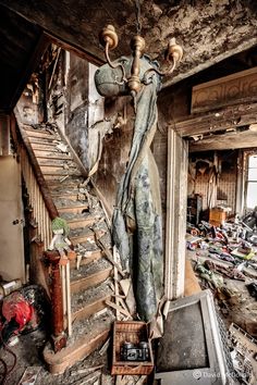 an old room with stairs and debris on the floor, including a lamppost in the middle