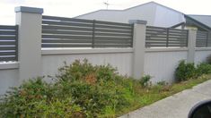 a car parked in front of a fenced off area with bushes and shrubs next to it