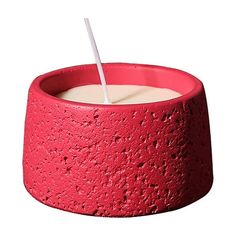 a red candle holder with a white stick sticking out of it's top and inside