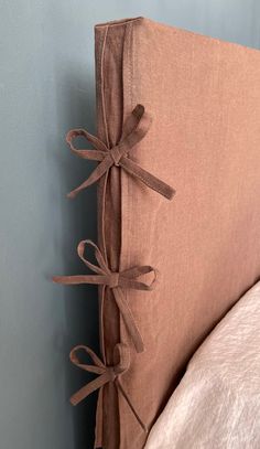 a close up of a pillow on a bed with ties tied to the back of it