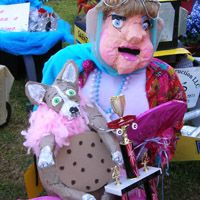 a large stuffed animal sitting on top of a chair next to a person in a costume