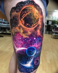 a man's leg with an image of planets and stars on it, in the middle