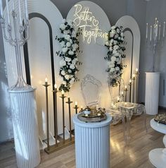 a room filled with lots of white furniture and flowers