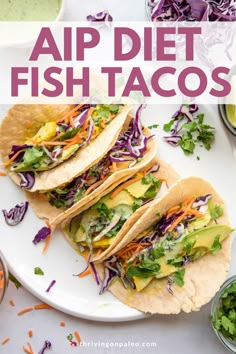 three fish tacos on a white plate with lettuce and carrots