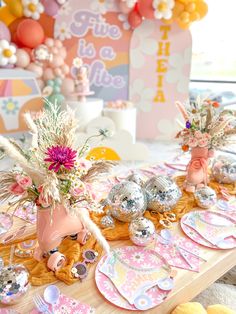 a table topped with lots of plates and vases filled with flowers