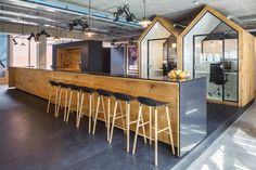 an open concept office with bar seating and stools in front of the counter area