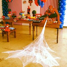 a spiderman themed birthday party with balloons and streamers on the wall, table