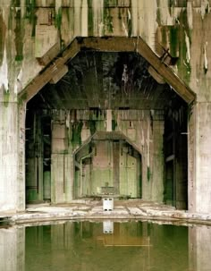 an abandoned building with water in the middle