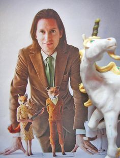 a man in a suit and tie standing next to two toy animals with one horse