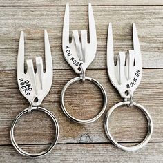 three pairs of personalized metal scissors with names on them sitting on a wooden surface